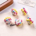 Detailed close-up of hand-painted donut-shaped acrylic beads with floral and heart patterns - White + Yellow Cream + Pink Flower + Blue Heart