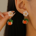 Vibrant orange fruit earrings with white floral stud accent worn by a model - KC Gold Persimmon