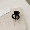 Pinza para el pelo en acetato negro brillante para mujer sobre fondo minimalista texturizado - Negro