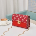 Mini red crossbody bag with golden horse print and leather texture in a cafe setting - Red