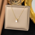 Detail of tear-drop pearl pendant with gold bead on a thin chain over a jewelry box - [XLH52] Perfume Bottle Necklace Gold