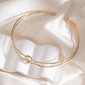 Polished gold choker featuring a knotted design with spheres on beige silk cloth - Gold Knotted Choker With Ball Ends