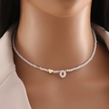 Girocollo di perline bianche con ciondolo a cuore e lettera O dorata su collo di modella - Lettera O