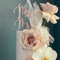 Close-up of rose gold Mr & Mrs acrylic cake topper with roses and orchids for wedding decor - Rose Gold MR&MRS Classic Style