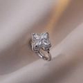 Elegant silver flower ring featuring micro-pave zircons on a soft fabric background - Silver Rotating Style / Silver