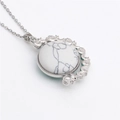 Macro shot of silver spinning pendant necklace with white marble and celestial moon patterns - White Marble/Metal Chain