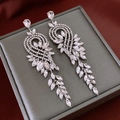 Macro view of silver tassel bow earrings with crystal leaf accents on a grey jewelry box - Silver Wheat Tassel (30#)