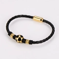 Dettaglio del bracciale in pelle intrecciata con ciondolo calcio dorato e chiusura magnetica - Oro