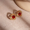 Detalle de pendientes de flores doradas con cristales rojos y pequeños diamantes - Rojo