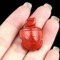 Miniature red jasper turtle figurine held by hand showing small size and natural texture - Red Jasper