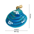 Detailed macro of 18K gold plated shell pendant with blue enamel and white faux pearl - Light Blue Pearl Shell