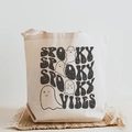 Cream canvas tote bag featuring spooky vibes text and cartoon ghost print design - Spooky Vibes Black Text