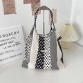 Close-up of polka dot canvas tote bag featuring double woven handles and brand label - Vertical Stripe Polka Dot Black