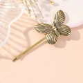 Vue détaillée d'une barrette papillon en or vintage avec une texture métallique - Or Antique