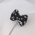 Macro shot of black beaded bow brooch with sparkling silver rhinestones and metal pin - Black and White