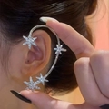 Detailansicht der silbernen Ohrmanschette mit funkelnden Strasssteinen am Ohrläppchen - Schneeflocke Stern Stil / Silber Schneeflocke Stern Linkes Ohr