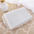 Close-up of light gray cotton muslin baby blanket with elegant lace trim - Gray