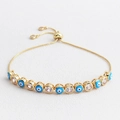Detail view of gold adjustable evil eye bracelet with blue enamel and clear zircons - Sky Blue