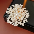 Dettaglio spilla a fiore con perle fatta a mano e filo dorato su scatola in pelle - Bianco latte