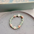 Detail of beaded ceramic bracelet with pastel green, pink beads and white cross charm - Leaf - Green