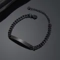 Dettaglio macro del bracciale ID nero in acciaio con piastra lucida e catena cubana - groumette catena / Nero
