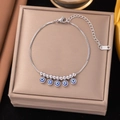 Silver stainless steel bracelet with blue evil eye charms on a golden jewelry box - Evil Eye Box Chain Bracelet (E2051) / Silver