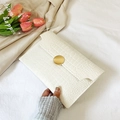 White faux crocodile envelope clutch featuring a round gold buckle and chic aesthetic - White