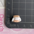 Miniature resin rabbit bead for DIY crafts measured on a centimeter grid mat - Puppy Sandwich Bread Head
