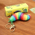 Portachiavi lumaca arcobaleno con campanello dorato e anello su tavolo in legno - Colorato