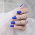 Primer plano de uñas postizas azul mate con anillos de plata sobre encaje blanco - Azul Profundo Mate (DFYM-04)