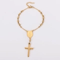 Detail of gold beaded rosary bracelet featuring a Virgin Mary medal and polished cross pendant - Gold
