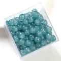 Teal marble-textured round jade-style beads stored in a transparent square plastic box - Lake Blue Apple Bead