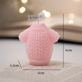 Pink knit sweater shaped scented candle with tag on a warm bokeh background - Pink Sweater - Peach Oolong