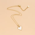 Elegante collar de corazón en acero de titanio dorado con nácar sobre fondo beige - Nácar blanco