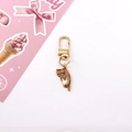 Detail of cute light brown kitten keychain with golden D-ring clasp on pink card - Light Brown Cat