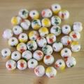 Macro detail of white ceramic beads with colorful hand-painted floral patterns on wood - No.41-Multicolor Hand Painted