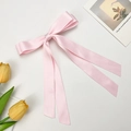 Detailed view of pink satin ribbon bow with long streamers and silk texture - Light Pink