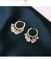 Dettaglio di orecchini a cerchio dorati con cristalli tondi e pendenti a frangia lucidi - Stile Pendente Multicolore / Oro Zircone Bianco