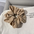 Détail d'un chouchou en satin beige avec strass brillants pour une queue de cheval élégante - Kaki