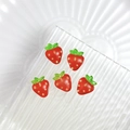 Five cute red resin strawberry nail art charms on a clear glass plate for DIY jewelry - Strawberry