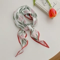 Detailed shot of tulip print silk scarf with red edges and elegant floral pattern - Dark Red Tulip