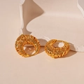 Nahaufnahme der goldenen gewebten Textur auf geometrischen Creolen mit Metallic-Finish - Gold