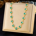 Dettaglio di una collana dorata con gemme blu a forma di cuore disposte in un cerchio - Stile Cuore Blu (N3401)