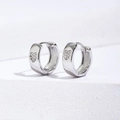 Macro view of wide hoop earrings with micro-inlaid heart zircon stones in silver - 11mm / Silver