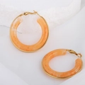 Exaggerated gold earrings with orange marble resin inlay on white stone surface - Grapefruit Color