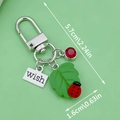 Metal keychain featuring a green leaf charm and silver tag engraved with Wish - Green Resin Leaf Ladybug