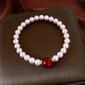 Dettaglio di bracciale di perle con grande perla di agata rossa e distanziatori argento - Stile Perla Rosa Agata Rossa
