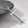 Nahaufnahme des silbernen Edelstahl-Kreuzanhängers mit religiöser Gravur an der Seite - Silber