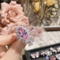 Nahaufnahme eines Rings mit rosa Markiseschliff-Kristall vor elegantem Blumenhintergrund - Stil 0374-Großer Rosa Marquise-Edelstein