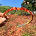 Handmade gold metal headband with red natural crystal stones held against a bright sky - Double Row / Red Agate-Double Row